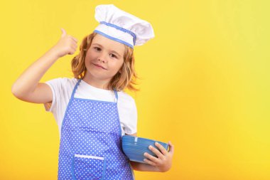 Aşçıbaşı aşçı çocuk. Heyecanlı aşçı şefi. Çocuk fırın üniforması ve aşçı şapkası giyiyor yemek hazırlıyor, stüdyo fotoğrafı çekiyor.