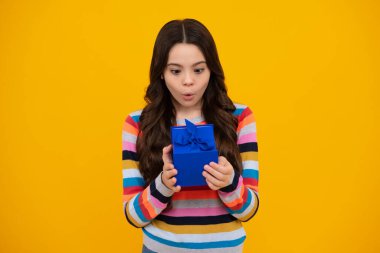 Şaşırmış yüz, şaşırmış genç kız duyguları. Hediye kutusu olan ergen bir çocuk. Tatil hediyesi. Mutlu yıllar, Sevgililer Günü, Yeni Yıl ya da Noel. Çocuk hediye kutusunu tut