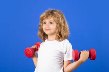 Kid raising a dumbbell. Cute child training with dumbbells. Kids fitness. Kid boy exercising with dumbbells. Healthy kids