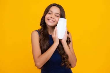 Child with shampoo conditioner. Daily cosmetic care. Teenager hold bottle of hair and skin care. Beauty health and cosmetics