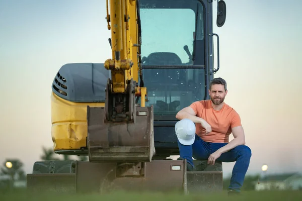 Construction man industry with excavator at industrial site. Worker in helmet build with bulldozer. Engineer work with builder contractor in hardhat. Excavation foreman with tractor