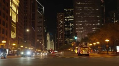 Chicago, ABD - 30 Nisan 2023: Chicago şehir merkezi gece manzaralı yol ve gökdelen, yavaş çekim.