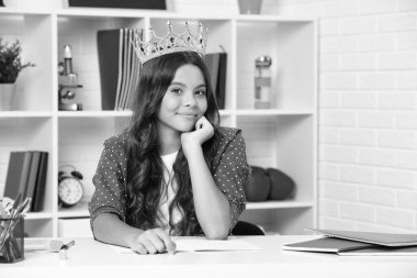 Little queen wearing golden crown. Teenage girl princess holding crown tiara. Prom party, childhood concept. Happy girl face, positive and smiling emotions