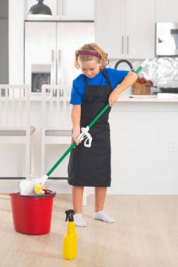 Çocuk ev işlerine yardım ediyor, temizlik yapıyor. Çocuk temizleme, konsept büyüme, gelişme, aile ilişkileri portresi