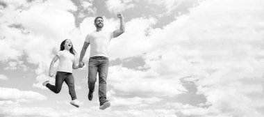 Baba ve kızı gökyüzüne sıçrıyor, fotokopi alanı olan bir pankart. Mutlu baba ve kız gökyüzüne atlıyor. Mutlu çocukluk.