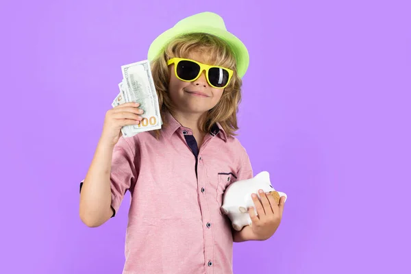 Saving money for travel. Dollars money and piggybank concept. Child boy putting in piggy bank usd dollar banknotes