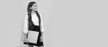 Okul üniformalı mutlu çocuk bilgisayar ve eğitim tutuyor..