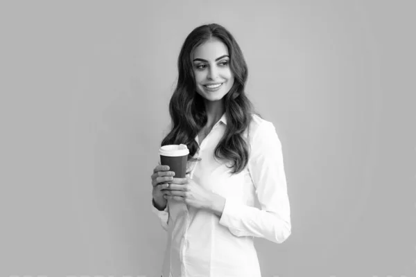 演播室里拿着咖啡的美女 照片上 一个快乐而积极的漂亮姑娘 拿着一大杯咖啡 在灰色的背景下 带着牙齿地孤零零地笑着 — 图库照片