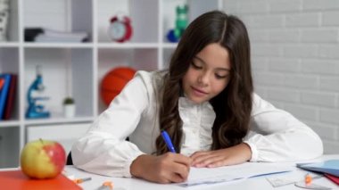 Ders, bilgi ve dilbilgisi kitabında çocuk yazmakla meşgul.