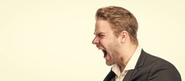 Öfke kükremesi. İş adamı öfkeyle bağırıyor. Kızgın yönetici. İnsan yüzü portresi, fotokopi alanı olan pankart. Takım elbiseli bir iş adamı, izole stüdyo geçmişi var.