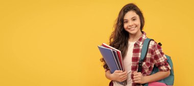 Gülümseyen öğrenci. Eğitim ve bilgi. Lisede. Not defteri ve sırt çantası olan bir kız öğrenci. Öğrenci portresi, stüdyo afişi. Okul çocuğu yüzü, boşluklar
