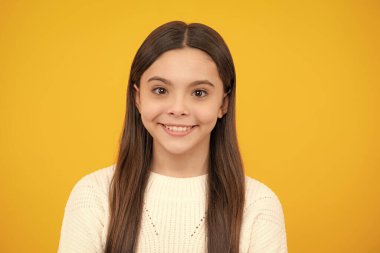 Portrait of cute positive little girl isolated on yellow background. Attractive caucasian child smiling and looking at camera