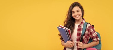 Gülümseyen öğrenci. Eğitim ve bilgi. Lisede. Not defteri ve sırt çantası olan bir kız öğrenci. Öğrenci portresi, stüdyo afişi. Okul çocuğu yüzü, boşluklar