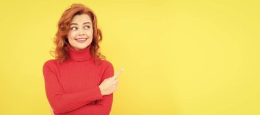 Mutlu kızıl saçlı kadın işaret ediyor, kopyala uzayı. pozitif duyguları ifade et