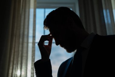 Yorgun adamın korkunç bir baş ağrısı var. Bitkin, sağlıksız hisseden, baş ağrısı hastalığına üzülen bir adam. Stresli orta yaşlı adamın başı ağrıyor. Migren ve baş ağrısı konsepti