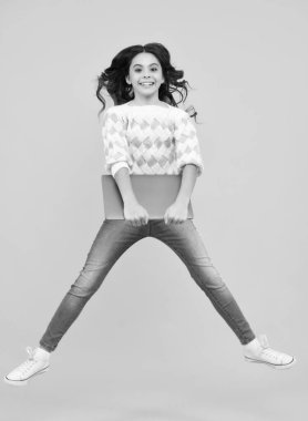 Dizüstü bilgisayar kullanan bir öğrenci. E-öğrenme ve çevrimiçi eğitim. Koş ve zıpla, zıplayan çocuklar. İnternetteki genç kız görüntülü sohbet stüdyo arka planında izole edilmiş.