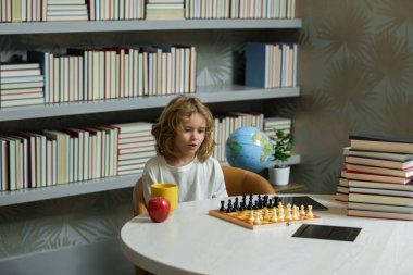 Satranç okulu. Çocuk sınıfta satranç oynamayı düşünüyor. Çocuk eğitimi konsepti. Zeki, zeki ve zeki okul çocukları.