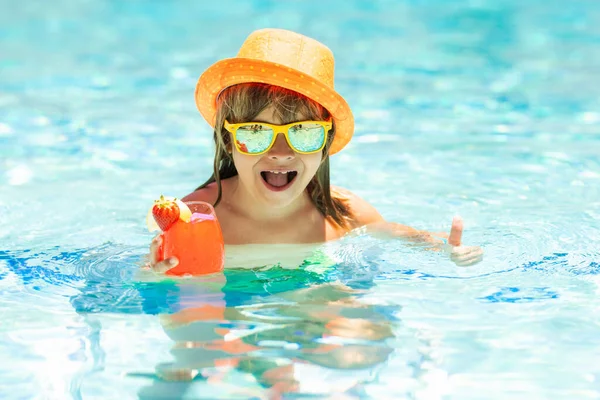 stock image Child drink cocktail in swimming pool. Active healthy lifestyle, swim water sport activity on summer vacation with child. Fashion summer kid boy in hat and sunglasses