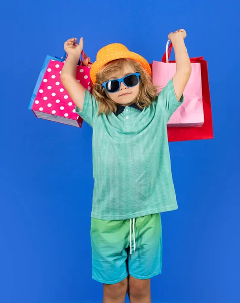 stock image Portrait of kid with shopping bag on blue isolated background. Portrait of a kid with shopping bags. Cyber monday, black friday. Small child enjoy shopping