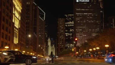 Chicago, ABD - 30 Nisan 2023: Yollu ve gökdelenli Chicago şehrinin gece manzarası, yavaş çekim.
