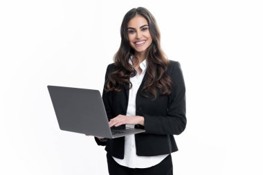 Portrait of a cheerful young casual girl standing isolated over gray background, using laptop computer. Business woman at work
