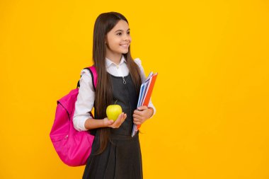 Okul çocuğu, okul çantalı genç kız. Sırt çantası taşıyıcı apolet ve sarı izole stüdyo geçmişi ile ilgili kitaplar. Çocuk okulu ve eğitim konsepti