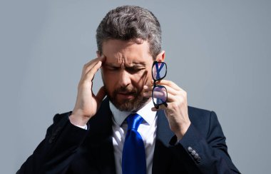 Gri stüdyo geçmişinde başı ağrıyan bir adam. Adam acıdan gözleri ovalayarak işten yorgun düşüyor. Stresli adam baş ağrısı ve görme bozukluğu çekiyor. Son teslim tarihi ve stresli iş
