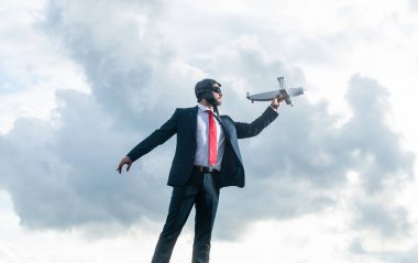 Takım elbiseli iş adamı ve pilot şapkalı uçak oyuncağı gökyüzünde. başlat.