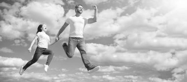 Baba ve kızı gökyüzüne sıçrıyor, fotokopi alanı olan bir pankart. Mutlu baba ve kız gökyüzüne atlıyor. dostluk.