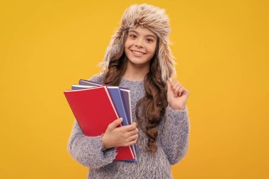 Olumlu duygularını ifade et. Kış modası. Şapkalı, kıvırcık saçlı, gülümseyen çocuk. Okula dönüyorum. Sarı arka planda örgü giyen genç bir kız. Kalın giysiler içindeki çocuğun portresi çalışma kitabını tutuyor..