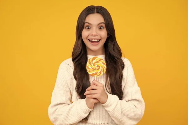 少女拿着黄色背景的棒棒糖 糖果店 青少年与糖果吸盘 少女快乐的脸庞 积极的微笑的情绪 — 图库照片