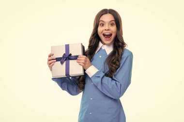 Emotional teenager child hold gift on birthday. Funny kid girl holding gift boxes celebrating happy New Year or Christmas