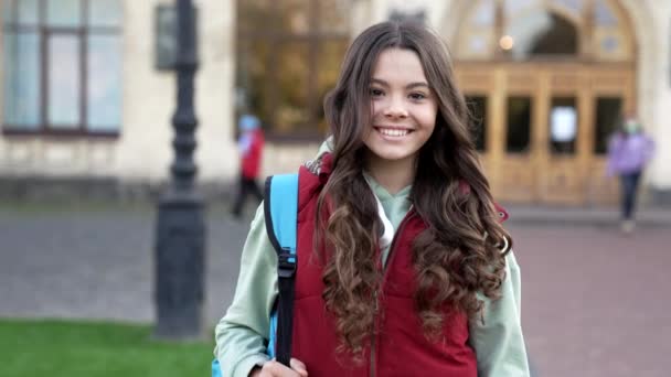 带着背包 微笑着上学的少女 在公园里学龄少女的慢动作 在户外上学的少女 外面的女学生 — 图库视频影像