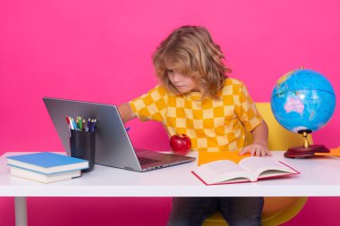 Okul öğrencisi sınıfta öğreniyor, okulda İngilizce öğreniyor. İlkokul çocuğu. Komik bir öğrencinin portresi.