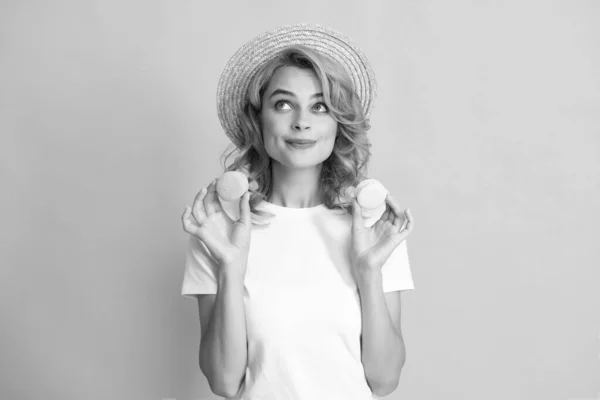 Stock image Young pleased woman isolated over yellow background eating macaroons. Girl eat french macarons