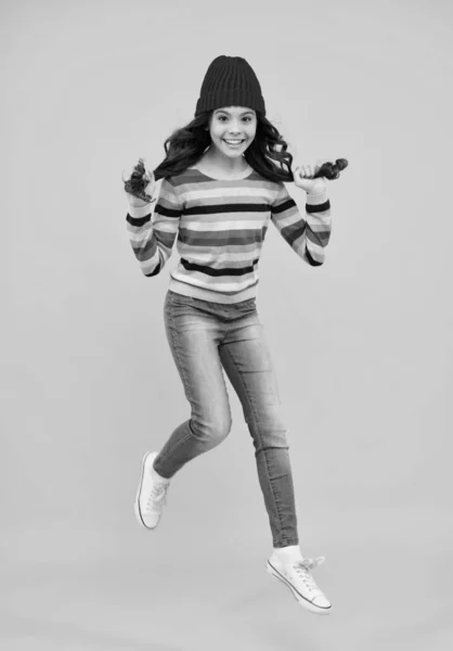 カラフルな青の背景に楽しさを持ってニット帽とセーターでファッション幸せな若い女性 ジャンプして走る 幸せなティーン 正と笑顔感情のティーン女の子 — ストック写真