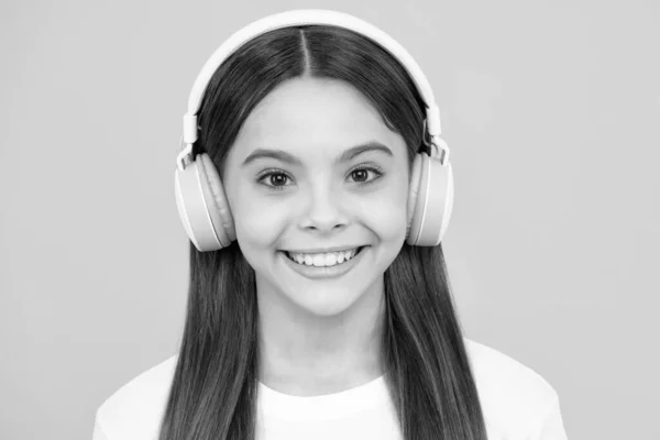 幸せなティーンエイジャーの肖像画 ヘッドフォンで音楽を聴くスタイリッシュな10代の女の子 子供のライフスタイルの概念 ワイヤレスイヤフォン 笑顔の女の子 — ストック写真