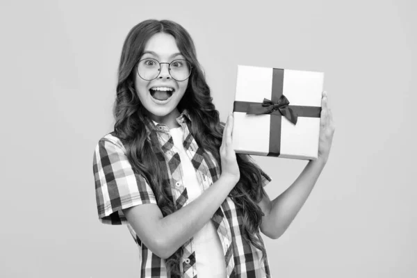 stock image Amazed teen girl. Child with gift present box on isolated background. Presents for birthday, Valentines day, New Year or Christmas. Excited expression, cheerful and glad