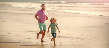 Banner of father and son run on summer sea beach. dad and child having fun outdoors. childhood and parenting. father and son.
