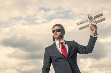 Takım elbiseli iş adamı ve pilot şapkalı uçak oyuncağı. Büyük düşün..