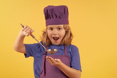 Mutfak kepçesiyle aşçı çocuk, stüdyo portresi. Yemek pişiren çocuklar. Aşçı çocuk sağlıklı yemek yapıyor. Stüdyo arka planında izole edilmiş, şef şapkalı küçük çocuk portresi.
