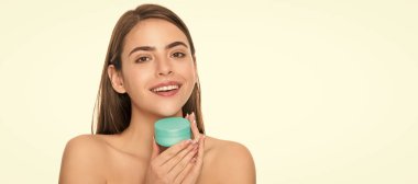 Kadın yüzü, yakın portre, kopyalanmış afiş. Mutlu genç kadın yüz için krem kavanozu tutuyor beyaz arka planda izole cilt, yüz bakımı