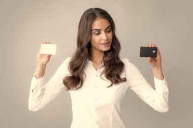 Woman holds template mockup bank credit card with online service isolated on gray background. Happy attractive young girl showing credit