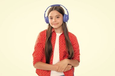 Child music concept. Teenager child girl dances in rhythm of melody, listens song in headphones. Child listening to music through earphones. Portrait of happy smiling teenage child girl