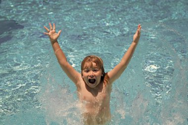 Funny excited little boy relaxing in a swimming pool, having fun during summer vacation in a tropical resort