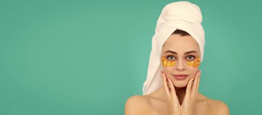 Göz bandı. Genç kızın yüzünde havluyla kolajen altın göz bantları var. Güzel kadın, izole edilmiş yüz portresi, taklit alanı olan pankart.