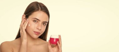 presenting female cosmetic product. woman applying face cream. young girl hold face mask. Woman beauty face, close up portrait, isolated banner with copy space