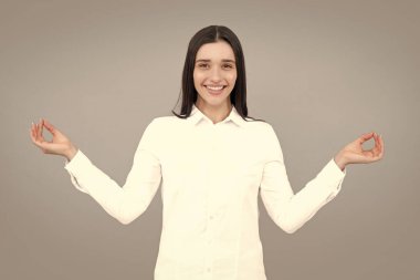 Portrait of attractive cheerful dreamy focused woman meditating. Young woman girl hold hands in yoga gesture relaxing meditating. Mindful peaceful woman meditates, keeps hands in mudra gesture