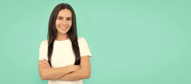 Mutlu esmer saçlı kadın. Gülümseyen kadın mutluluğu ifade eder. Gömlekli neşeli kız ellerini çapraz yaptı. İzole edilmiş yüz portresi, kopyalama alanı olan pankart