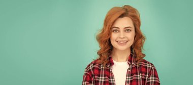 İzole edilmiş bir yüz portresi, kopyalanmış bir afiş. Kıvırcık saçlı neşeli bir bayan. Güzellik ve moda. Kareli gömlekli kadın model.